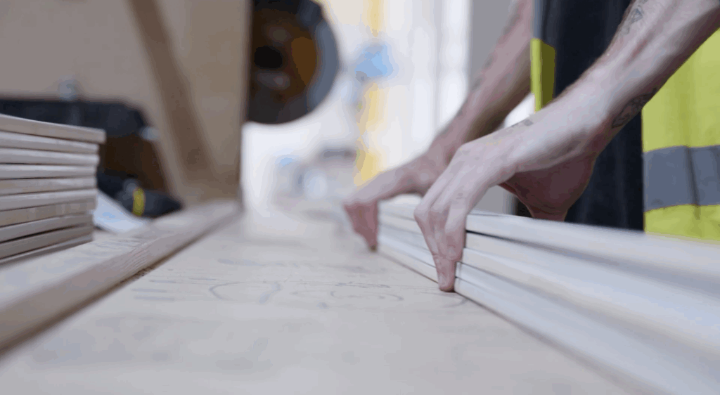 Sentry factory worker measuring wood